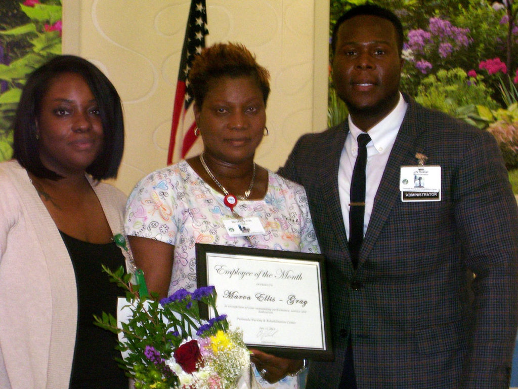 Ellis Gray posing with employee of the month award.